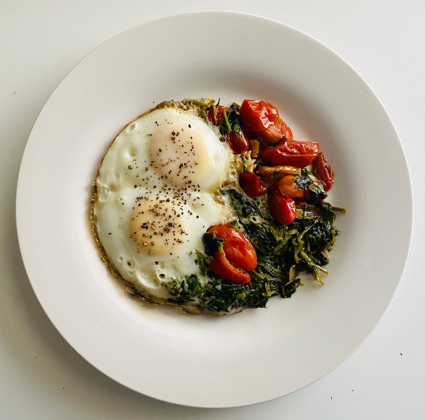 Fried Eggs with Blistered Cherry Tomatoes and Garlicky Greens